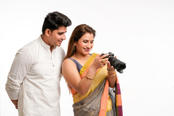 Indian couple using camera on white background