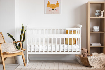 Interior of light bedroom with baby crib and shelving unit