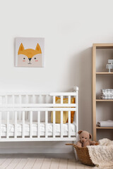 Interior of light bedroom with baby crib and shelving unit