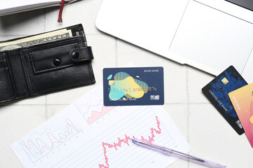 Wallet with money, credit cards and graphics on white tile table