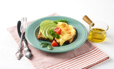 Omelette with tomato and avocado on bread, close up view.