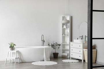 Naklejka na ściany i meble Interior of light bathroom with white sink, bathtub, shelving unit and houseplants