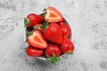 Bowl of fresh strawberries on grey grunge background