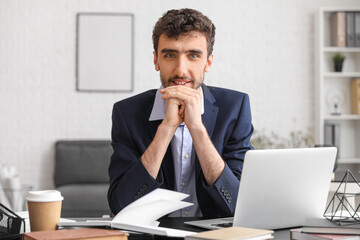 Young businessman working at table in office