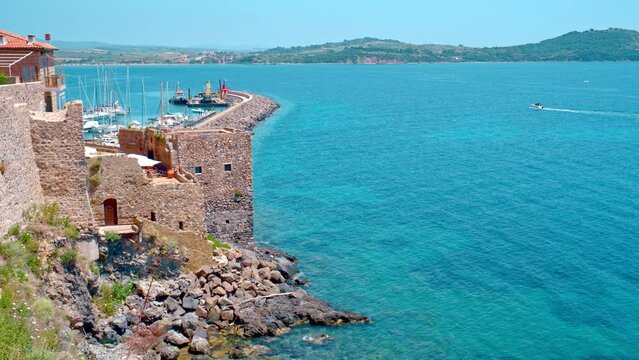 Talamone rocky beach and medieval fortress Rocca Aldobrandesca and walls. The village lies on a rocky promontory, in Maremma nature reserve, mount Argentario, Tuscany, Italy
