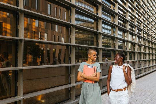 Joyful Co-workers Walking in Front of Business Building