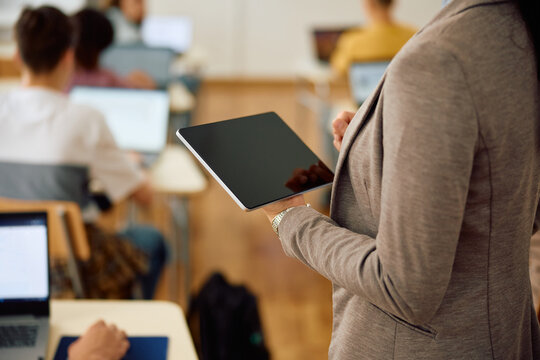 Close up of female teacher using digital tablet during computer class in classroom.