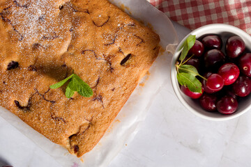 Sponge cake with a cherry on a light background