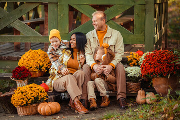 family traditions. multiethnic family i am in autumn in the park in a wooden gazebo next to pumpkins and flowers