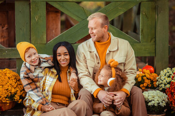 family traditions. multiethnic family i am in autumn in the park in a wooden gazebo next to pumpkins and flowers