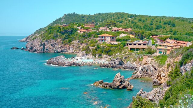 Talamone rocky beach and medieval fortress Rocca Aldobrandesca and walls. The village lies on a rocky promontory, in Maremma nature reserve, mount Argentario, Tuscany, Italy