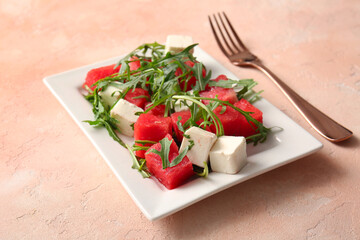 Plate of tasty watermelon salad on beige background