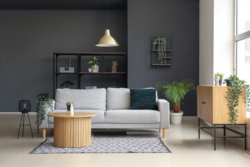 Interior of modern living room with comfortable grey sofa and wooden coffee table