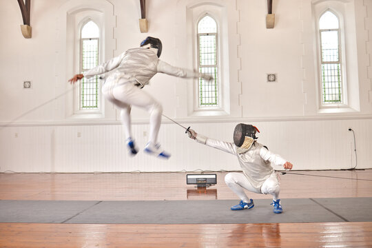 Fencing, exercise and people battle, jump and training, fitness or workout for energy with epee sword in club. Fight, fencer or athlete in performance, competition or sports with mask, helmet or suit