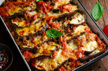 Eggplant Casserole, Roasted Eggplant Dish with Minced Meat, Tomato Sauce and Mozzarella over Rustic Background