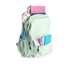 Green school backpack with notebooks, pencils case and pens on white background