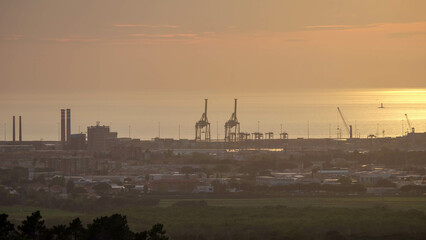 Strand von Livorno in Italien mit Industriehafen bei Sonnenuntergang Abendrot
