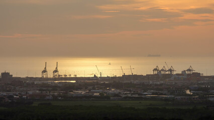 Strand von Livorno in Italien mit Industriehafen bei Sonnenuntergang Abendrot