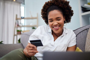 Happy black woman, laptop and credit card for ecommerce, payment or banking on sofa at home....