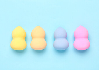 Different makeup sponges on blue background