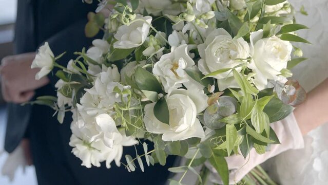 ウエディング・結婚式　ブーケを持って腕を組み並んで立つ新郎新婦　お祝い・セレモニー