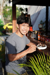 Happy Asian man enjoying chocolate brownie cake