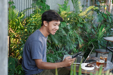 Naklejka na ściany i meble Young Asian man working at coffee shop