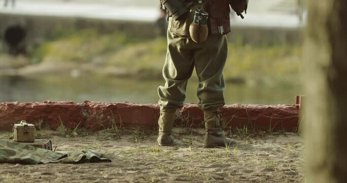 German Soldier Guards Mortar. Re-enactor Dressed As German Wehrmacht Infantry Soldier In World War Ii With Submachine Gun Mp 40 Patrols Territory Of Mortar Crew.
