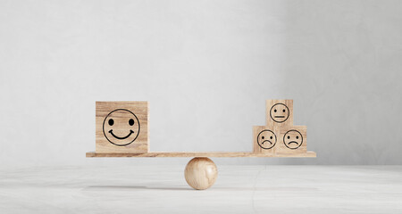 Happy and sad smiley faces on wooden seesaw. Customer satisfaction, evaluation or positive feedback...