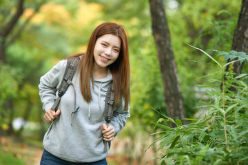 Fototapeta premium a young female college student traveling through the woods with a backpack