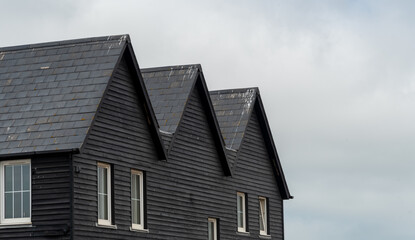 Wooden house roof attics against cloudy sky. Home residential building