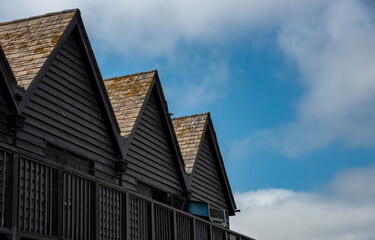 Fototapeta na wymiar Wooden house roof attics against cloudy sky. Home residential building