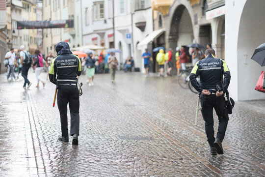 Bolzano, Italy - July 21, 2023: Two back turned policemen by polizia municipale, Stadtpolizei, municipal police of Italy, responsible to the mayors of the various municipalities of Italy