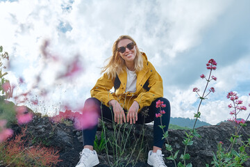 Hiking on tallest volcano in Continental Europe - Etna. Smiling young woman looking at camera near...