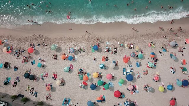 Footage 4k 25Fps: aerial view from the drone of the beach of Tropea in Calabria with the crystalline Caribbean sea, the bathers and the colored umbrellas. The video conveys a sense of peace and sereni