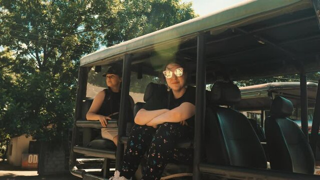 Two girls sitting in jeep waiting for safari trip. Sri Lanka.
