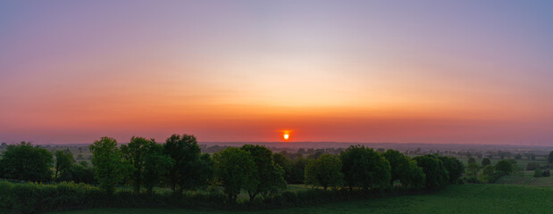 Naklejka premium Grünlandschaft im Sonnenuntergang 