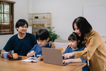 work from home education concept and family at home sitting at desk business woman working on internet in laptop child writing in notebook