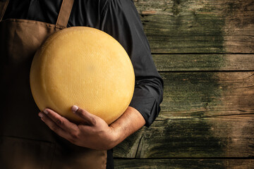 emmental semi-hard cheese with big holes on a wooden background, banner, menu, recipe place for...