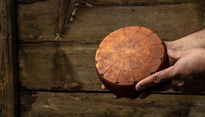 craftsmanship hands have a typical Italian cheese. French tomme cheese in the hands of a...