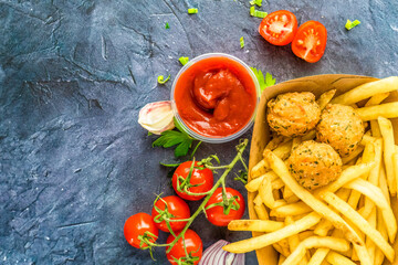 Fried potatoes with ketchup, decorated with tomatoes on a blue background.