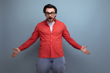 stylish surprised european 35 year old man in casual shirt throws up his hands