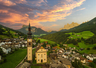 Medieval church tower in Dolomites, Italy, salt at sunset in the valley