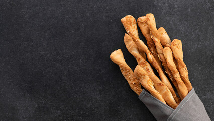 Grissini, bread sticks with parmesan on gray background, top view, place for text