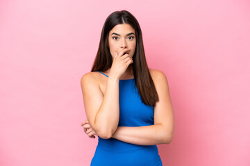 Young Brazilian woman isolated on pink background surprised and shocked while looking right