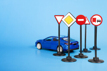 car and road signs on a blue background, road rules and safety guidelines to new drivers in driving schools, copy space