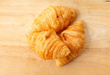 Fresh croissant on wooden background. Top view. Copy space.