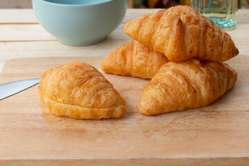 Croissants on a wooden table with a cup of coffee.