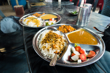 Delicious North Indian Platter: Dal, rice, and salad at a rustic Dhaba roadside restaurant in Uttarakhand, India. Mouthwatering local cuisine.
