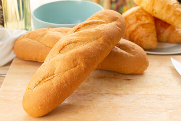 French baguettes on a cutting board with a cup of coffee